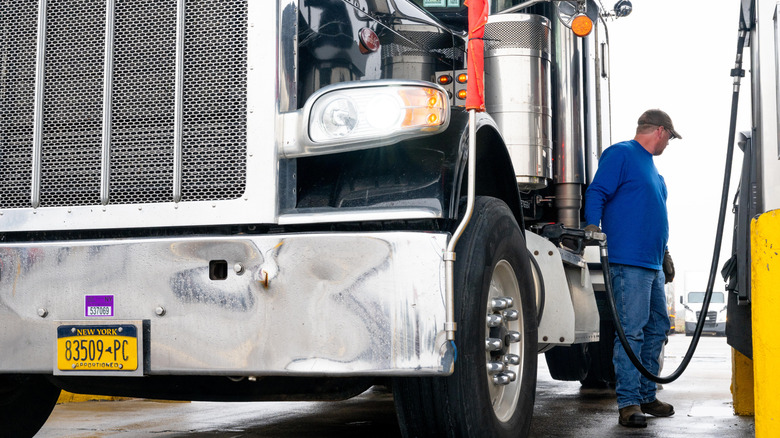 Man filling a semi-truck with diesel