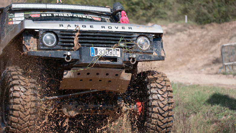 A modified Range Rover with custom suspension on an off-road course