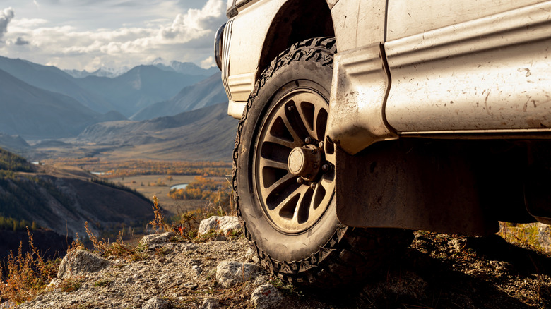 Close up shot of the wheel and suspension system over rocky terrain