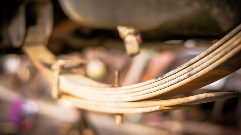 A close up image of an old leaf spring assembly