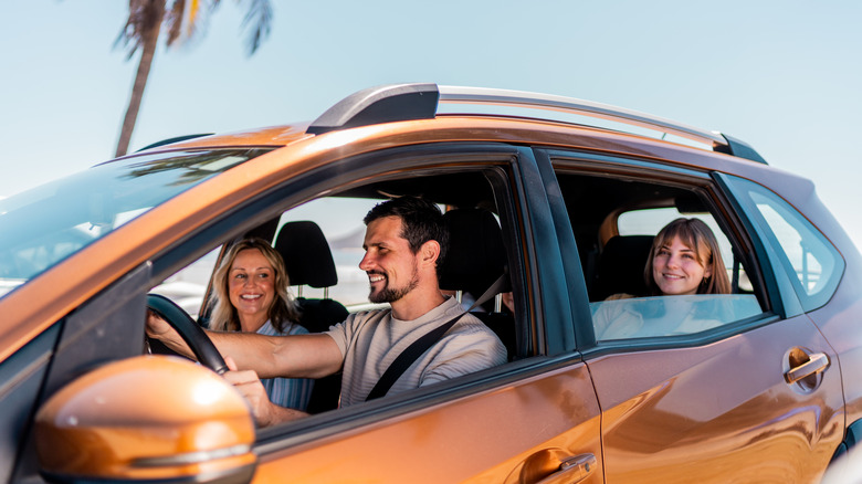A family in an orange crossover SUV.