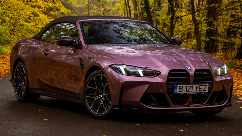 A purple BMW M4 Convertible in a forest