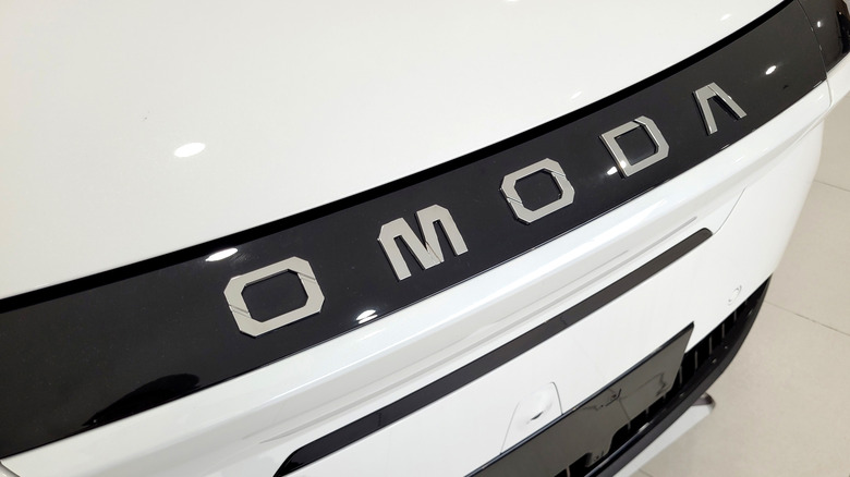 An Omoda Badge on the front of a white car