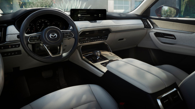 The interior of a Mazda CX-90 with light-colored fabric and leather