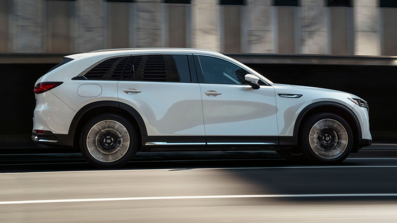 The side profile of a Mazda CX-90 while driving