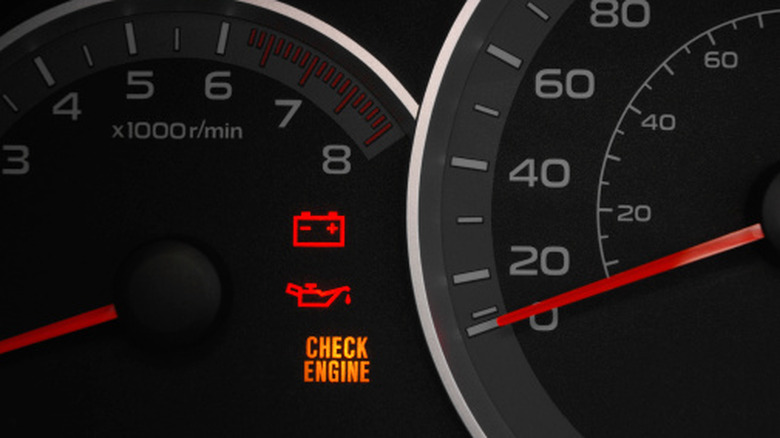 Car gauges with battery, oil, and check-engine lights illuminated