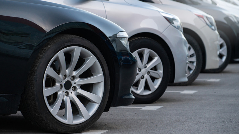A lineup of front car wheels on a dealership lot