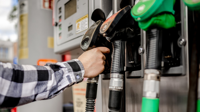 A man picking up a gas pump