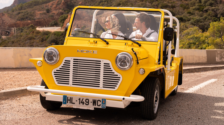 A yellow Moke Mk2 driving in France