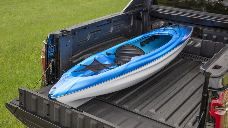 The rear bed of the Chevrolet Silverado EV RST carrying a canoe