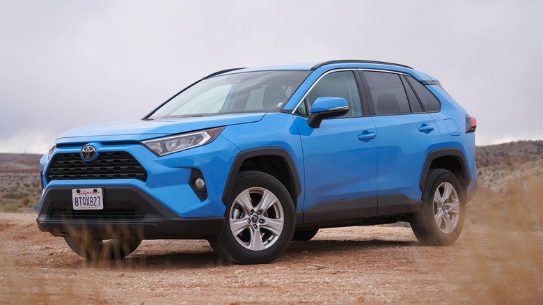 A blue Toyota RAV4 parked on a dirt road