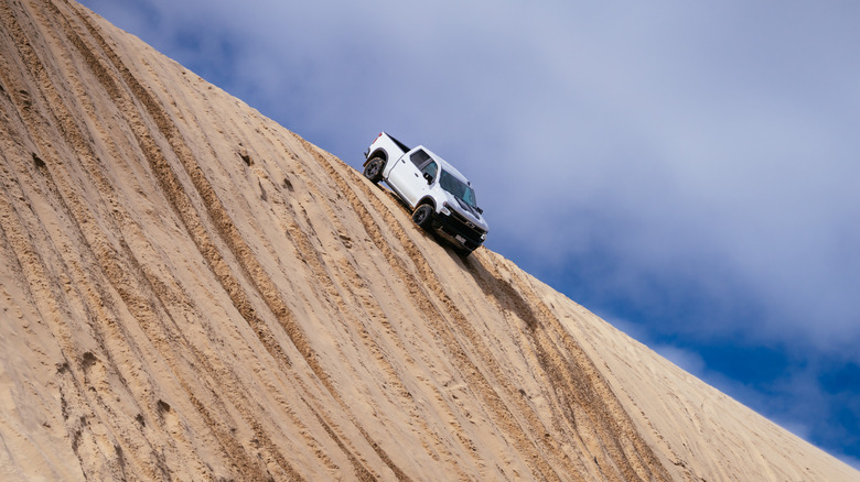 A Chevrolet Silverado ZR2 descending a steep sand dune