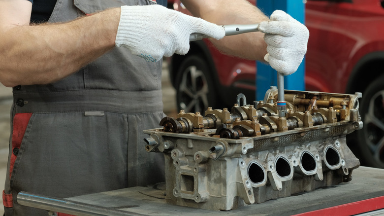 A mechanic working on a dissembled engine
