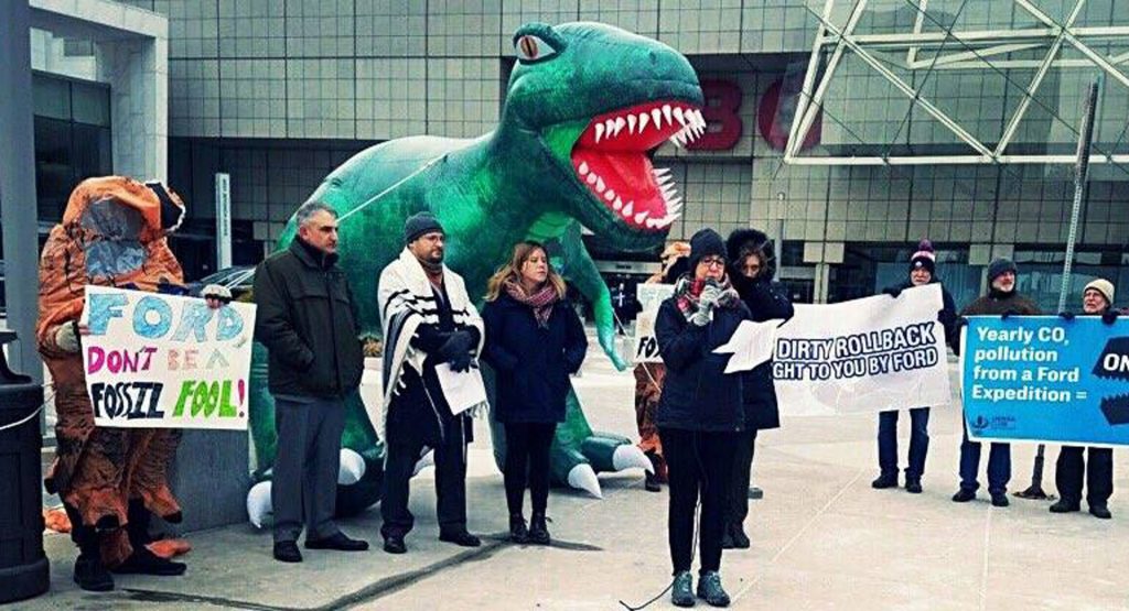  Groups Protest GM, Ford At Detroit Show With Prayers And… Inflatable T-Rex?